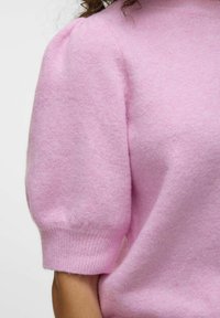 Jasnoróżowy sweter z dzianiny z krótkimi, bufkami rękawami oraz ribbowym wykończeniem. Tkanina wydaje się miękka i ma delikatną fakturę.