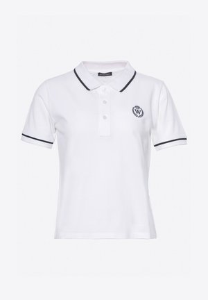 Camisa polo blanca con cuello negro y acabados en las mangas en negro. Presenta tres botones y un emblema circular en el lado izquierdo del pecho. Hecha de una tela texturizada.