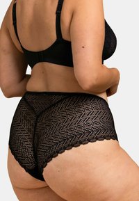 Ensemble de soutien-gorge en dentelle noire et culotte taille haute, avec une texture à motifs, des bords festonnés et des bretelles réglables.