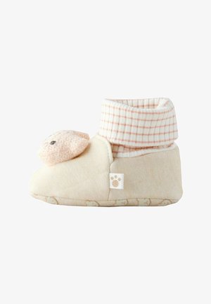 Blød beige babyfutteral med ternet manchet og et blødt får ansigt på tåen, med et poteaftryk mærkat på siden.