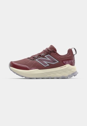 Maroon athletic shoe with a textured upper, grey accents, a thick cream midsole, and a rugged outsole. Features a pull tab at the heel.