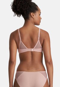 Light pink bra with adjustable straps and mesh panels. Back hook closure with a smooth, matte finish. Paired with matching light pink panties.