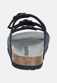 Black sandal with multiple straps, cork footbed, and textured gray insole. Features a contoured shape and rubber outsole for grip.