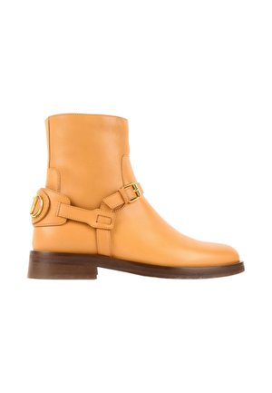 Bottine en cuir camel avec des sangles à boucles dorées et une semelle marron foncé, vue de profil sur fond blanc.