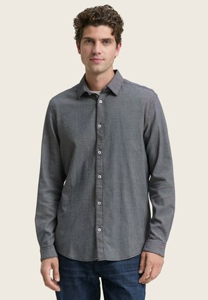 Camisa de manga larga a cuadros en blanco y negro con collar de botón, material de algodón, tejido texturizado y botones blancos.