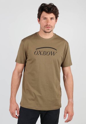 T-shirt en coton vert olive à manches courtes. Il présente un logo noir "OXBOW" centré sur la poitrine. Col sans couture, coupe décontractée.