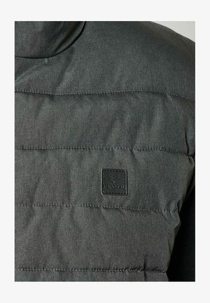 Grijs gewatteerd jack met een hoge kraag, voorzien van een textuurstof, horizontale stiksels en een zwart logo op de borst.