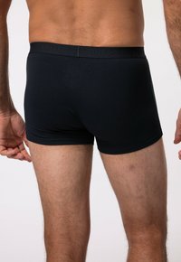 Shorts en coton noirs de type boxer avec un design ajusté et une taille élastique arborant le logo en relief "JP1880". Texture douce et finition lisse.