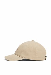 Gorra de béisbol de algodón beige con visera curva, acentos bordados en la parte frontal y una correa ajustable de metal en la parte trasera.