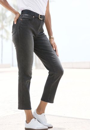 Melni džinsi ar taisnu kāju un augstu jostasvietu, ar piecām kabatām un metāla sprādzi. Kombinēti ar baltām kedām un minimāliem aksesuāriem.