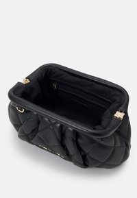 Svart kviltad handväska tillverkad av mjukt läder med guldfärgad hårdvara. Inuti finns en ficka med dragkedja och en slät tygfoder. Hållbar och strukturerad form.