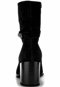 Bottines en daim noir avec un talon structuré, un accent de sangle décoratif et des détails texturés sur la tige de la bottine. Semelle lisse.