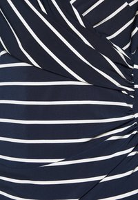 Mörkblått tyg med vita horisontella ränder, med en draperad design och gatherad textur på ena sidan. Mjukt och töjbart material.