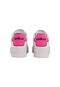 Sneakers bianchi con toppe in gomma rosa sul tallone che presentano la scritta "GAËLLE" in nero. Suole in gomma con una texture liscia e forma arrotondata.