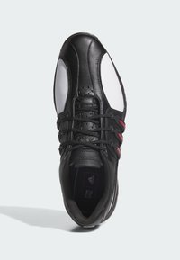 Czarno-białe trampki z czerwonymi akcentami, z gładką skórzaną cholewką, sznurowanym zapięciem oraz perforacjami na czubku buta.
