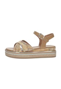 Sandali platform beige con cinturini incrociati caratterizzati da una stampa mappa, accentuati da una suola in simil-juta intrecciata e dettagli metallici. Cinturino alla caviglia regolabile.