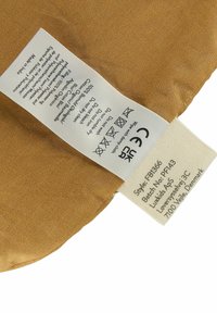 Medvilninis audinys šiltos rudų spalvų tonacijoje su lygiu paviršiumi. Prisegtas priežiūros ženklas su skalbimo instrukcijomis ir prekės ženklo duomenimis.