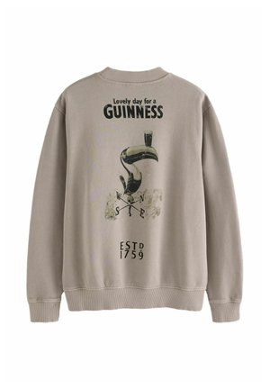 Světlé béžové tričko s potiskem tuka a nápisem "Lovely day for a GUINNESS", se žebrovaným výstřihem a lemem.