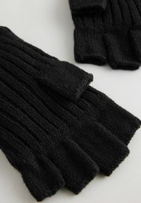 Sorte strikkede fingerløse handsker med ribbet tekstur, der har en tætsiddende pasform og en blød finish. Åbne fingerspidser for smidighed.