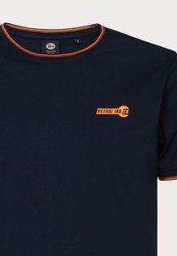 Námornícky modré tričko s krátkym rukávom a oranžovými akcentmi, okrúhly výstrih a grafika "PETROL IND. CO." v jasnej oranžovej farbe na �ľavej hrudi.