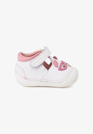 Chaussure pour tout-petit blanche et rose avec une bride Velcro, panneaux latéraux ouverts et visage d'ours décoratif rose et beige sur le bout.