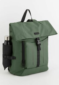 Grön vattentät ryggsäck med rulltoppsdesign, vadderade axelremmar, framfickor med dragkedja och en sidficka för en vattenflaska.