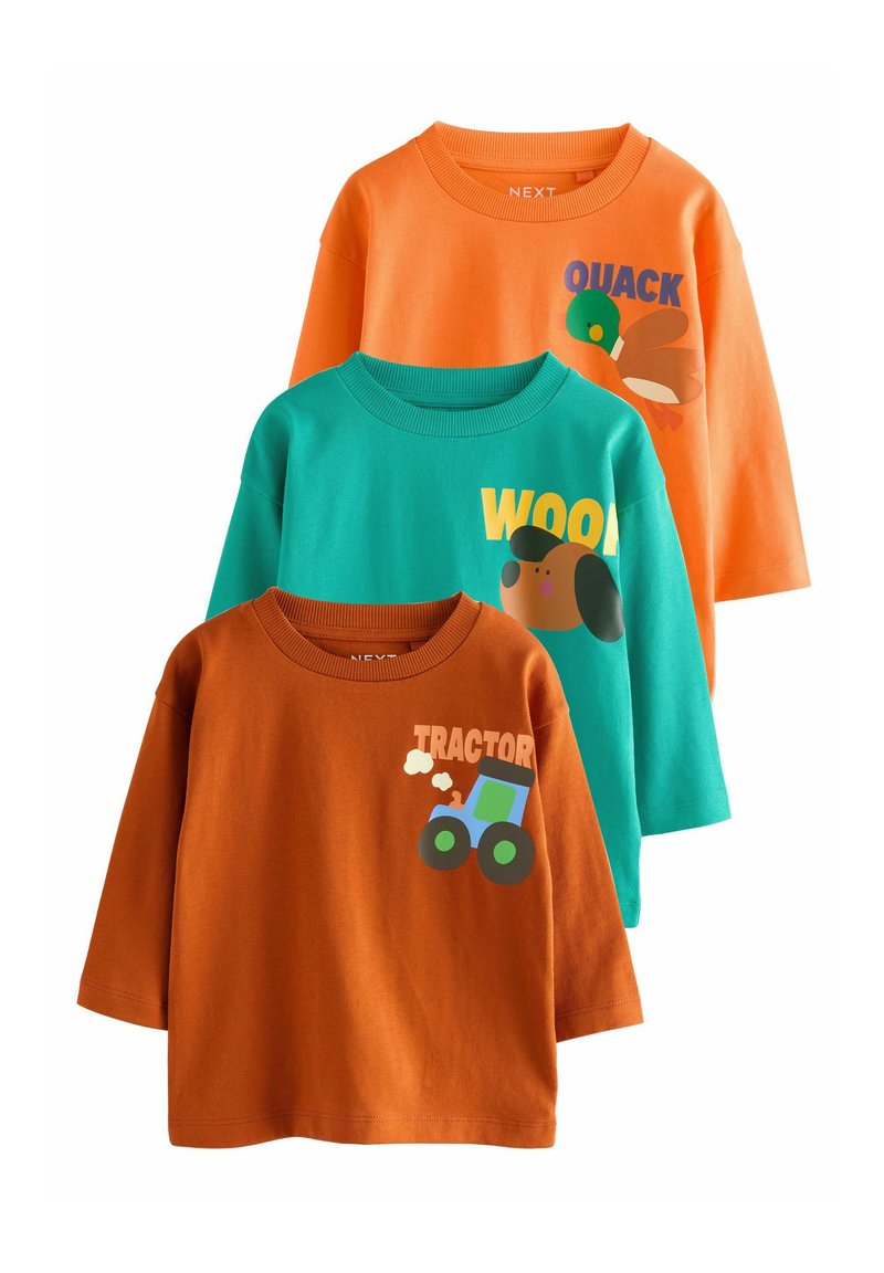 Drei langärmlige Baumwollshirts: orange mit einem Entenmotiv, blaugrün mit einem Hund und "WOOD", und rostfarben mit einem Traktor-Motiv.