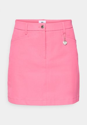 Rozā svārki ar piegulošu jostu, priekšējiem kabatām un pogu aizdari. Iekļaujas dekoratīvs metāla piekariņš un gluda, viegla auduma.