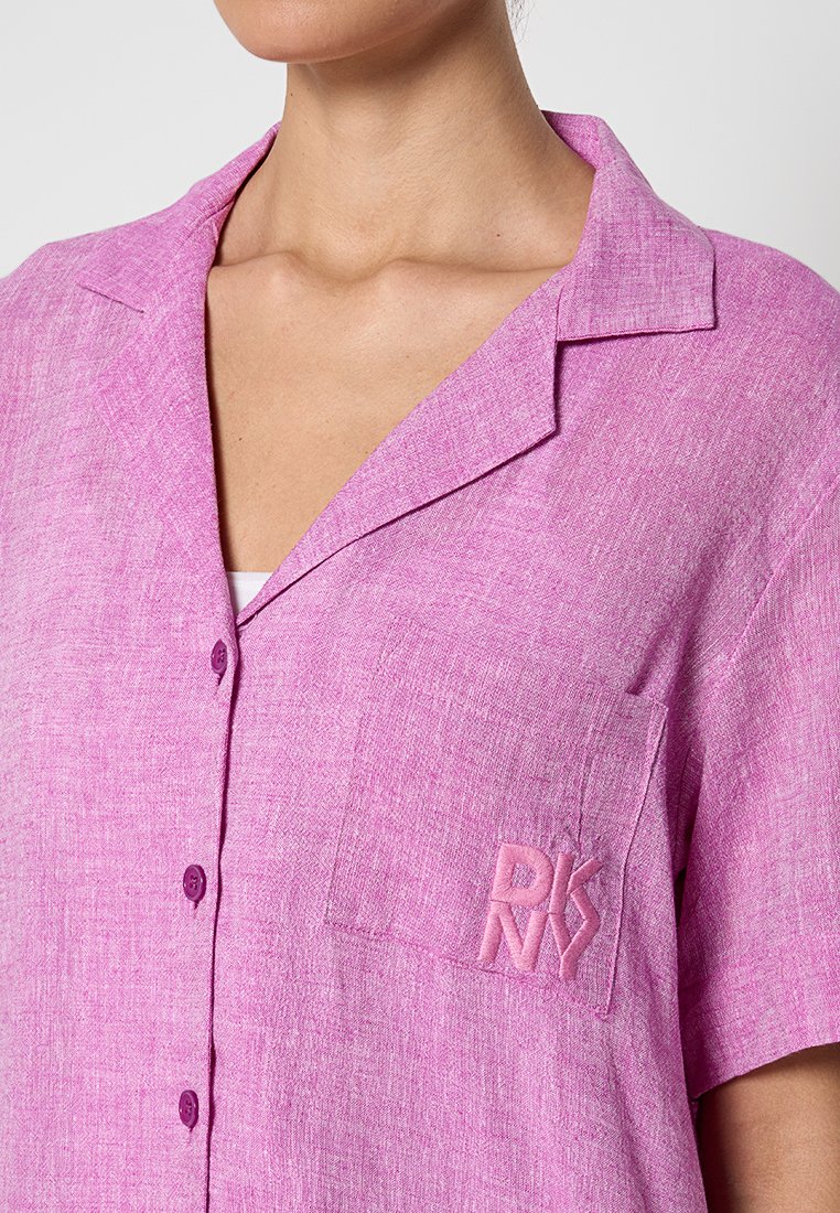 Różowa lniana koszula z kołnierzykiem, krótkimi rękawami i kieszonką na piersi z haftowanym logo "DKNY". Guziki w dopasowanym odcieniu.