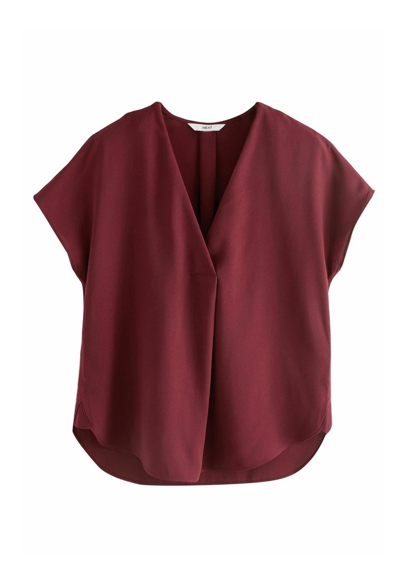 Blouse bordeaux à manches courtes, col en V et coupe ample, avec un ourlet légèrement arrondi et une couture centrale.