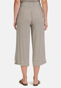 Bruine culottes met een patroon, gemaakt van een lichtgewicht materiaal. Geometrisch ontwerp in wit en beige, met een ontspannen pasvorm en cropped lengte.