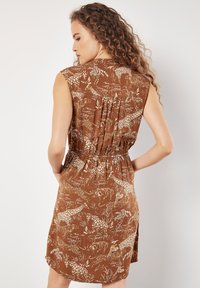 Braunes ärmelloses Kleid mit Tier- und Blattdruck, gerafftem Bund und gefaltetem Rückendetail. Leichter Stoff und knielanger Schnitt.