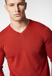 Czerwona, długosleeve sweter w dekolcie w serek o prążkowanej strukturze i dopasowanym kroju. Gładki materiał o subtelnym połysku.