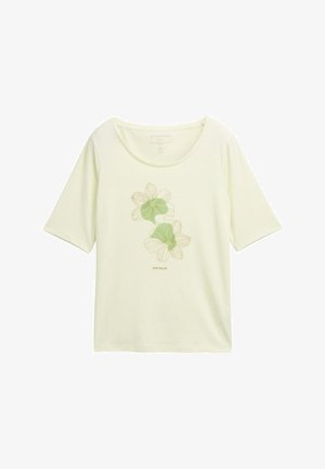 Heledad kollane T-särk, mis on valmistatud pehmest kangast, rohelise kontuuriga lillemustriga, ümar kaelus ja lühikesed varrukad.