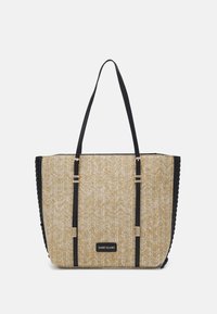 Beige woven tote bag with black accents, features two handles, gold-tone hardware, and a textured pattern on the surface.