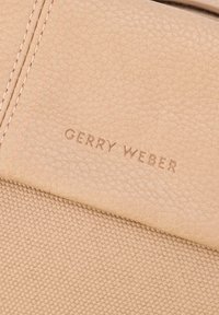 Beige tekstureret lædertaske med kontrasterende stofpanel. Præget "GERRY WEBER" logo. Syede detaljer tilføjer karakter. Ren, minimalistisk design.