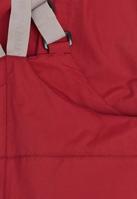 Rood stoffen overall met verstelbare beige bretels, met een gladde textuur en nauwkeurige stiksels. Voorzien van een zijzak voor opbergruimte.