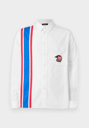 White button-up shirt featuring a blue and red striped design on one side and a black embroidered helmet patch on the chest pocket.