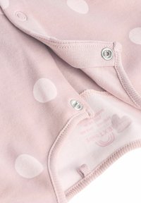 Világos rózsaszín bodysuit fehér pöttyökkel, patentos záródással és puha pamut anyagból készült. Belső címkével rendelkezik.