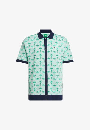 Rövid ujjú póló ing mentazöld alapon, tengerészkék gallérral és gombokkal, amelyek ismétlődő virágmintát ábrázolnak különböző zöld árnyalatokban.