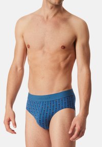 Blauwe herenboxers met een patroon van verticale lijnen in verschillende kleuren. Zachte stof en een elastische tailleband met branding.