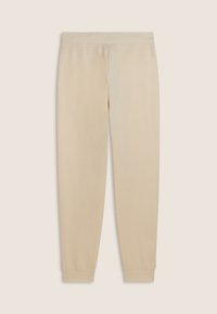 Pantalones deportivos beige con una tela suave, piernas ajustadas y puños elásticos. Presenta una cinturilla plana para mayor comodidad y sin patrones visibles.