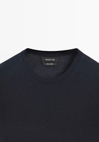 Ciemnoniebieski sweter z okrągłym dekoltem wykonany w 100% z kaszmiru. Posiada gładką fakturę, prosty wzór oraz metkę wewnątrz.