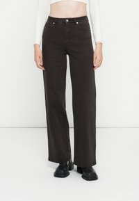Donkerbruine wijde jeans met hoge taille, twee voorzakken en rafelrand. De stof heeft een gladde textuur met een lichte glans.