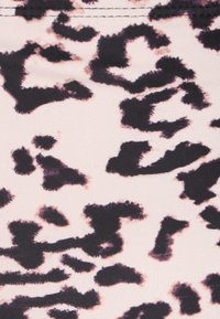 A lábnyom mintás anyag puha, sima textúrával, amely sötétbarna és fekete foltokat tartalmaz világos rózsaszín háttérrel.