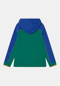 Sudadera con capucha que presenta un cuerpo verde, mangas azules, puños naranjas y costuras en contraste. Tejido suave, corte relajado y sin marcas visibles.