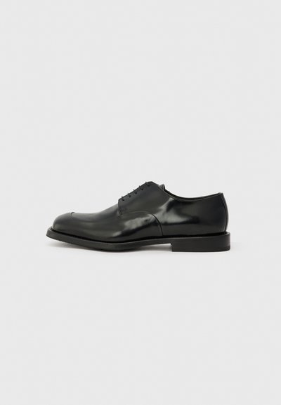 Schwarze Leder-Oxfordschuhe mit glänzender Oberfläche, runder Zehenform, fünf Schnürösen und flacher Gummisohle. Glatte Textur mit minimalen Akzenten.