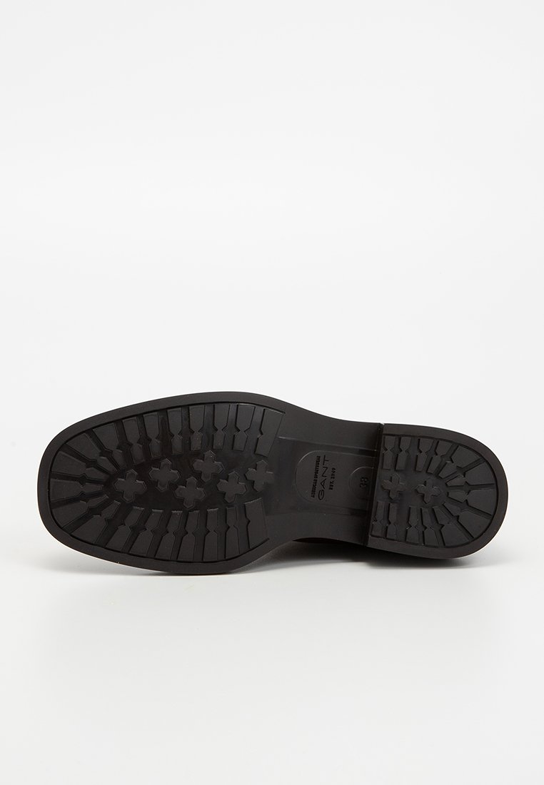 Schwarze Gummisohle mit einem robusten Profilmuster, ausgestattet mit einem Logo und einer Größenmarkierung. Glatte Oberfläche mit einem abgerundeten Absatzdesign.