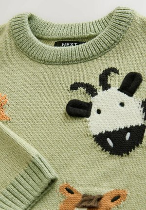 Green knitted sweater featuring animal designs, including a black and white cow face, with textured accents and a ribbed neckline.