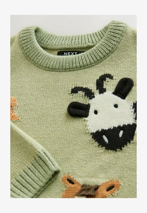 Pulover verde tricotat cu modele de animale, inclusiv un chip de vacă alb-negru, cu accente texturate și un guler striat.